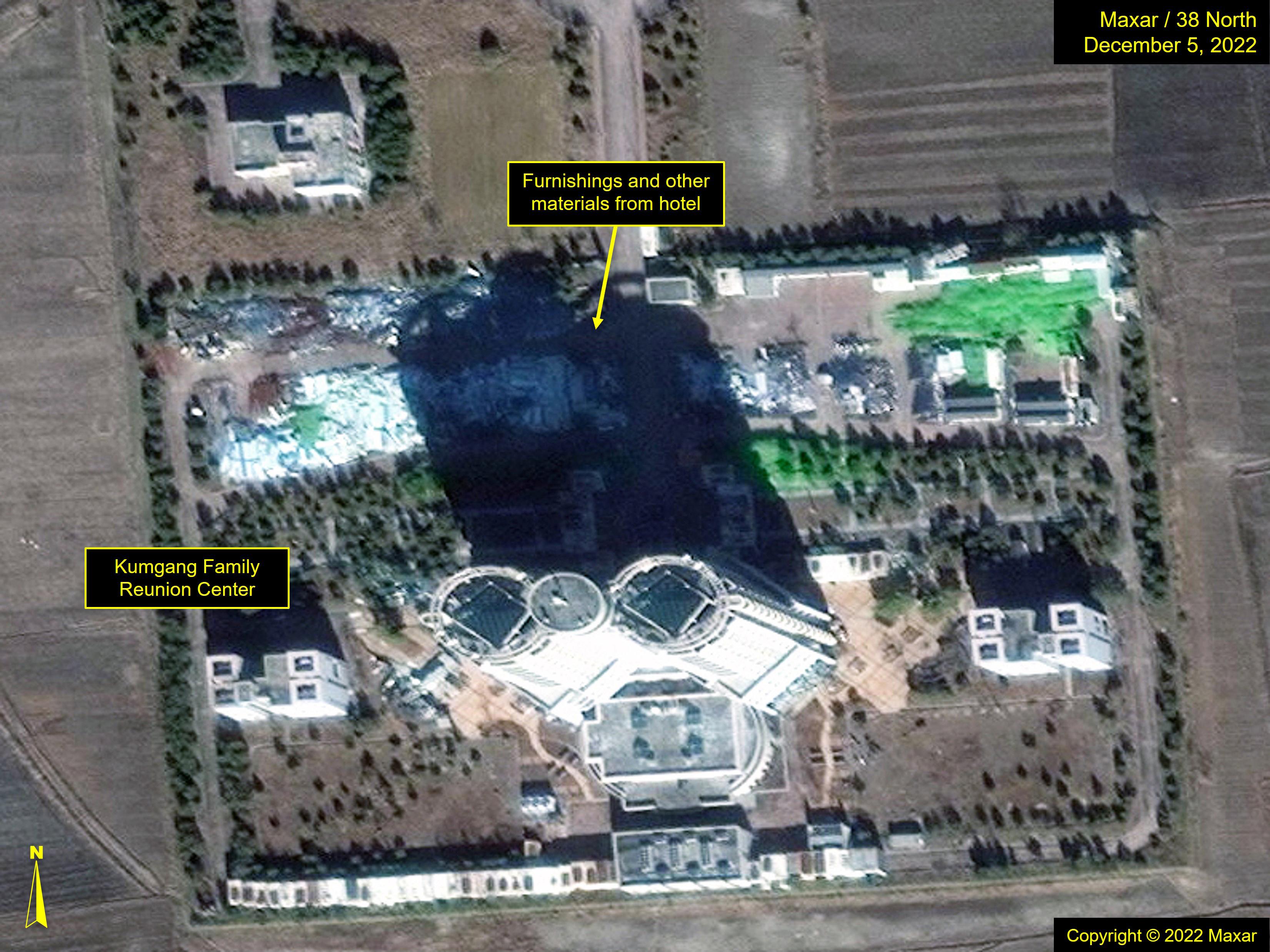 Figure 17. Debris and materials from inside the Kumgang Family Reunion Center have been piled up in the hotel's parking lot. The exterior of the structure appears unchanged.